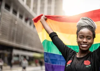 African american woman holding a pride flag 